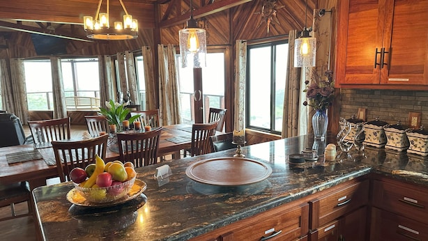 Une cuisine spacieuse dotée de meubles en bois, d’un plan de travail en granit et d’un coin repas avec une table et des chaises.