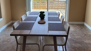 A dining area with a table and chairs, a potted plant, and a view of a wooden deck and greenery outside. - Big house for the big family! 6 bedrooms and 3.5 bathrooms.  (Kitchener)