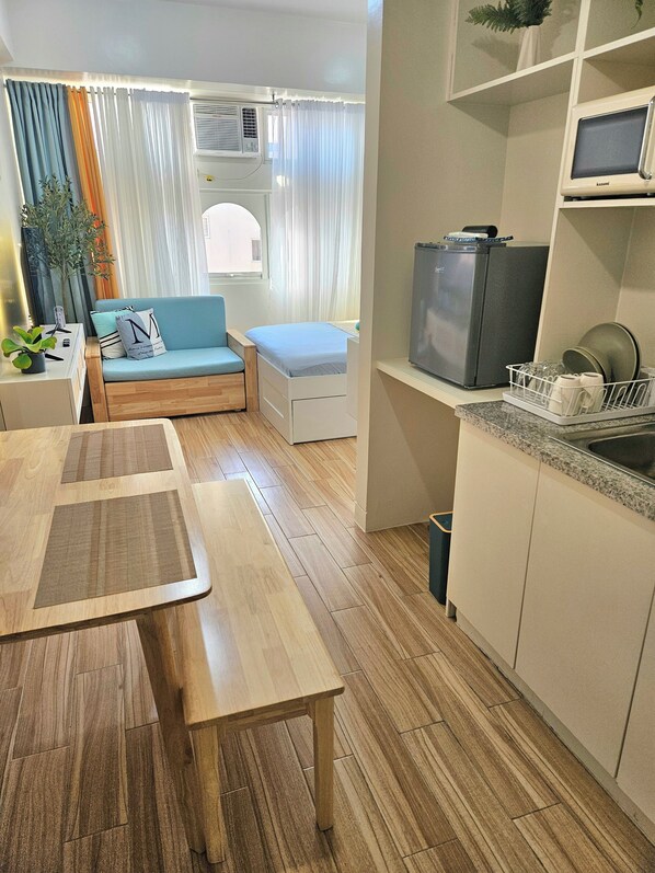 Cozy living space with a kitchenette, dining table, and comfortable sofa.