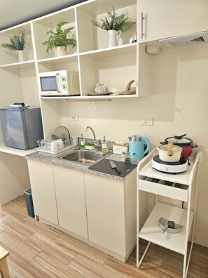 Compact kitchen with central island, sink, stovetop, and ample storage.