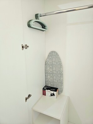 Bathroom features a minimalist design with a white door, silver handle, and towel rack.