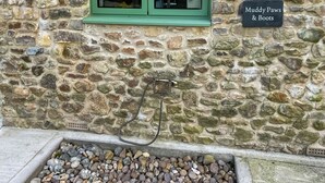 A stone wall with a window and a sign reading 'Muddy Paws & Boots.' - Charming four-bed holiday home in Yarcombe sleeps eight. (Yarcombe)