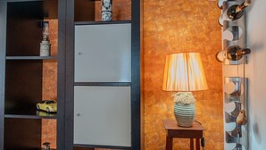 Een kamer met een houten kast, een lamp en een wandrek voor wijn.