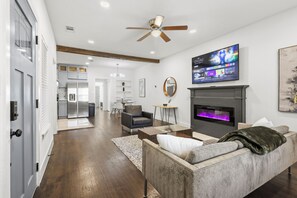 A modern living room with a fireplace, a television, and a ceiling fan. - Charming renovated 1bed/1bath duplex  in Oaklawn/Uptown Dallas TX (Dallas)