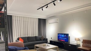 A modern living room with a sofa, coffee table, and TV.