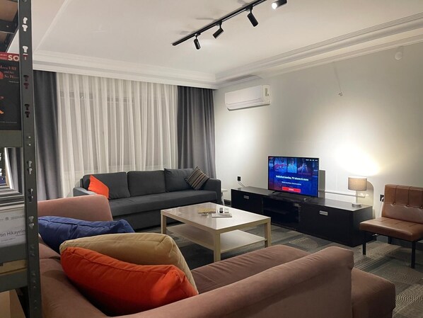 Een moderne woonkamer met een bank, salontafel en televisie.