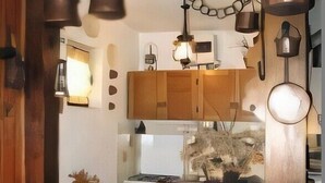 Una cocina compacta con armarios de madera, una estufa blanca e iluminación colgante.