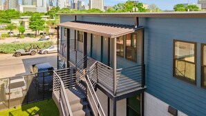 A modern building with a balcony and a city skyline in the background. - East Austin Condo - 2 Bedrooms & Parking (Austin)