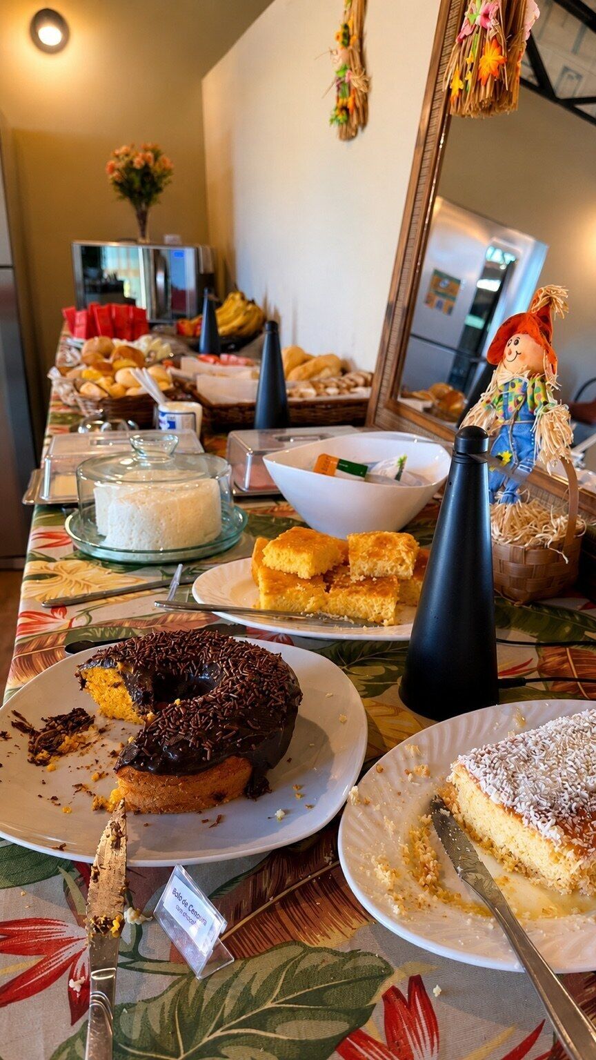 Une table de buffet garnie de divers plats, notamment des gâteaux et des pâtisseries, ainsi qu’une poupée décorative.