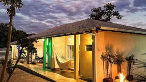 Una casa con hamaca, una fogata y un espacio de patio.