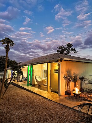 Ein Haus mit Hängematte, Feuerstelle und Terrassenbereich.