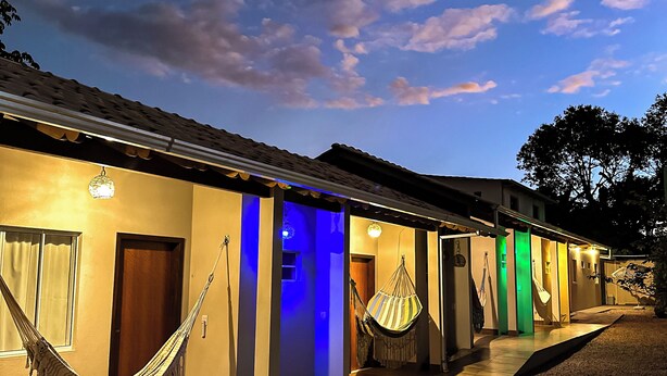 Una casa moderna con una hamaca, un sillón hamaca y una entrada bien iluminada.