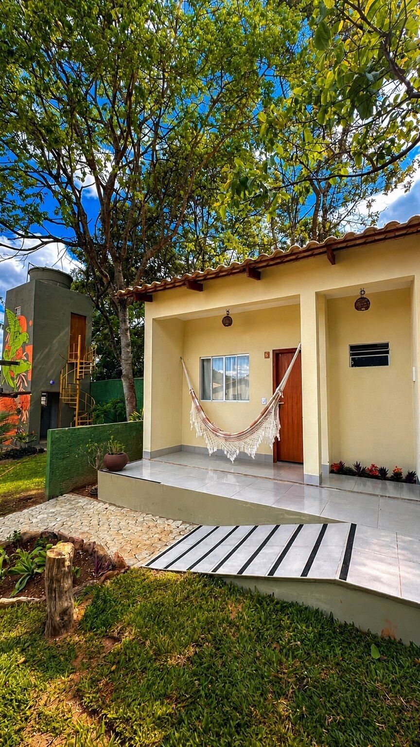 A modern house with a hammock, a small garden, and a mural on the side.