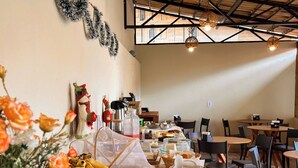 Un comedor con mesas, sillas y diversos alimentos exhibidos.