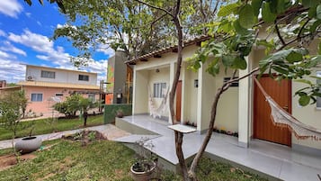 Un edificio residencial con balcón, hamaca y un pequeño jardín.