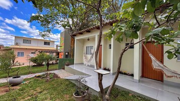 Un edificio residencial con balcón, hamaca y un pequeño jardín.