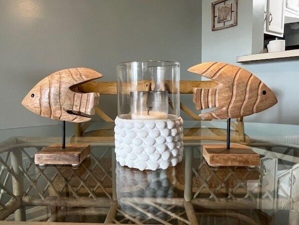 A glass table with two wooden fish sculptures on either side.