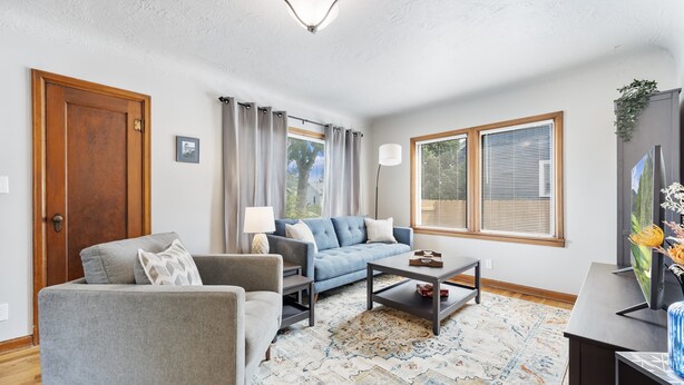 A living room with a sofa, armchair, coffee table, and a rug. - 3 bed 1 bath W. Bannock Beauty (Boise)