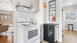 A compact kitchen with a white stove, black dishwasher, and a small countertop. - 3 bed 1 bath W. Bannock Beauty (Boise)