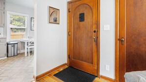 A hallway with a wooden door, a doormat, and a small rug. - 3 bed 1 bath W. Bannock Beauty (Boise)