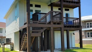 Une maison à deux étages avec un balcon et un escalier.