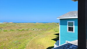 Une maison située sur la côte, offrant une vue dégagée sur l’océan.
