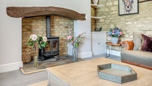Un salon chaleureux avec une cheminée, un canapé, une table basse et des vases décoratifs.