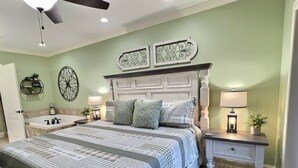 A bedroom with a bed, two nightstands, a ceiling fan, and decorative wall art. - Updated~ Legacy Manor, 2br, 2ba,  Downtown Gatlinburg, Walking Distance to all (Gatlinburg)