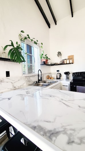 A kitchen with marble countertops, a sink, a stove, and various kitchen items. - Cozy 2-bedroom bungalow in the outskirts of San Ignacio with WiFi, AC (San Ignacio)