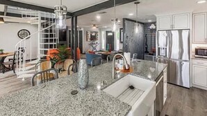 A modern kitchen with granite countertops, stainless steel appliances, and a central island.