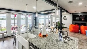 A modern kitchen with a granite countertop, stainless steel appliances, and a view of the outdoors.