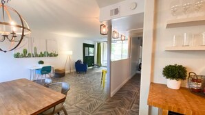 A modern interior with a wooden dining table, a chandelier, and a patterned floor. - Cozy 1-bedroom, resort style condo. w/ WiFi, AC in beautiful Scottsdale (Scottsdale)