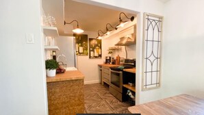 A compact kitchen with modern appliances, pendant lighting, and a patterned floor. - Cozy 1-bedroom, resort style condo. w/ WiFi, AC in beautiful Scottsdale (Scottsdale)