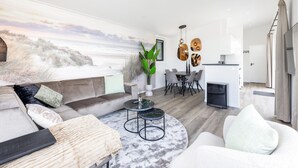 Una sala de estar moderna con sofá, mesa de centro y comedor.