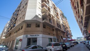 A multi-story building with a sign for "Vanesa del Oro Policlinica" on the ground floor. - 097 - Club Náutico 012 - comfortHOLIDAYS (Santa Pola)