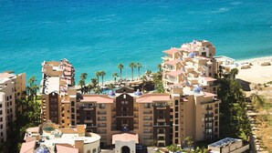 A multi-story hotel with a pool, beach access, and palm trees. - Confirmed reservation 2 bdrm suite at Villa Del Arco Great views,  on the beach. (Cabo San Lucas)