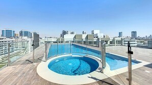A rooftop pool with a clear view of the city skyline. - Luxury 1BR Near Miracle Garden |Uni Estate Supreme (Arjan)