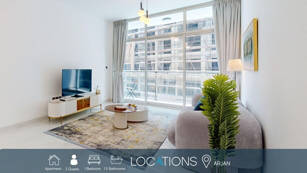 A modern apartment with a large window, a flat-screen TV, a round coffee table, and a potted plant. - Luxury 1BR Near Miracle Garden |Uni Estate Supreme (Arjan)