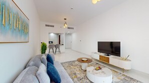 Relax in this stylish living room with a grey sofa, round coffee table, and flat-screen TV.