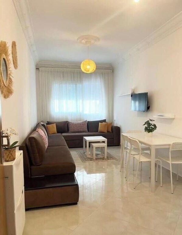 Una sala de estar moderna con sofá, mesa de centro, mesa de comedor y sillas.