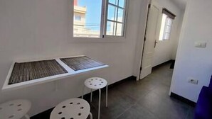 Una habitación con ventana, radiador y una pequeña mesa.