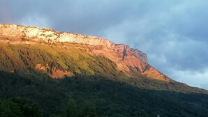 A mountain with a rocky cliff and dense forest. - ECOLE A GITER - NID D'AIGLE (SAINT FRANCOIS DE SALES)