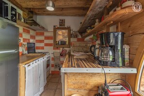 Une cuisine compacte équipée d’un réfrigérateur, d’une cuisinière, d’une machine à café et d’un grille-pain.