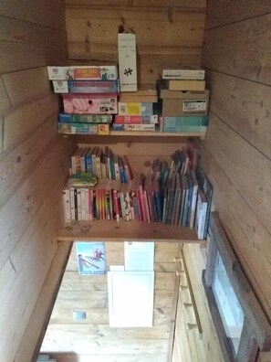 Un intérieur en bois avec des étagères remplies de livres et de boîtes.