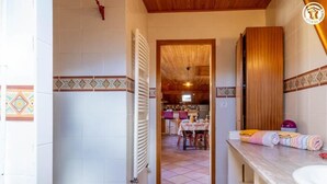 Un baño con lavamanos blanco, muebles de madera y piso de baldosas.
