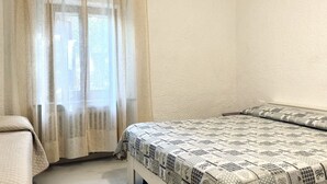 A bedroom with a bed, a window with sheer curtains, and a plain wall. - RM11 - Senigallia, three-room apartment facing the sea (Senigallia)