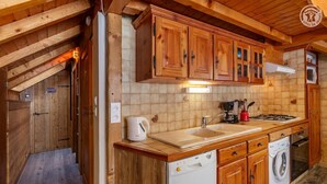 A wooden cabin interior with a kitchen area featuring wooden cabinets, a sink, a coffee maker, and a washing machine. - LE VALLON - VALLOIRE (VALLOIRE)