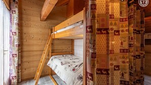 A cozy cabin room with a bunk bed, wooden walls, and patterned curtains. - LE VALLON - VALLOIRE (VALLOIRE)