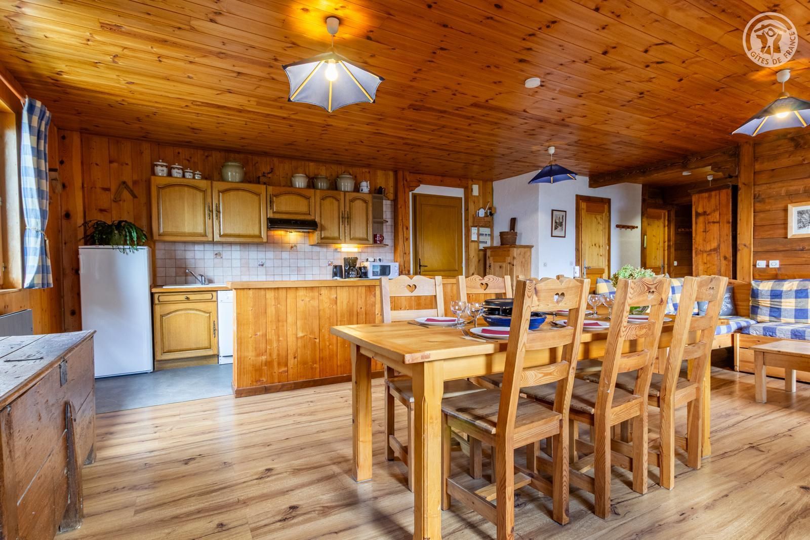 Un interior de madera con comedor, cocina y un ventilador de techo.