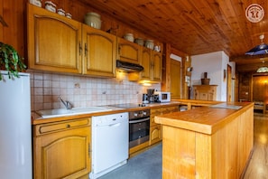 A kitchen with wooden cabinets, a dishwasher, a microwave, and a coffee maker. - Chalet l'Echaillon - Ormelune (SAINTE FOY TARENTAISE)